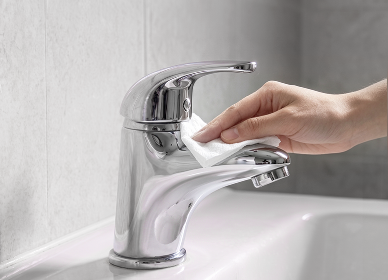 Wiping the bathroom faucet clean